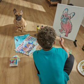 boy painting dog on laminate floor